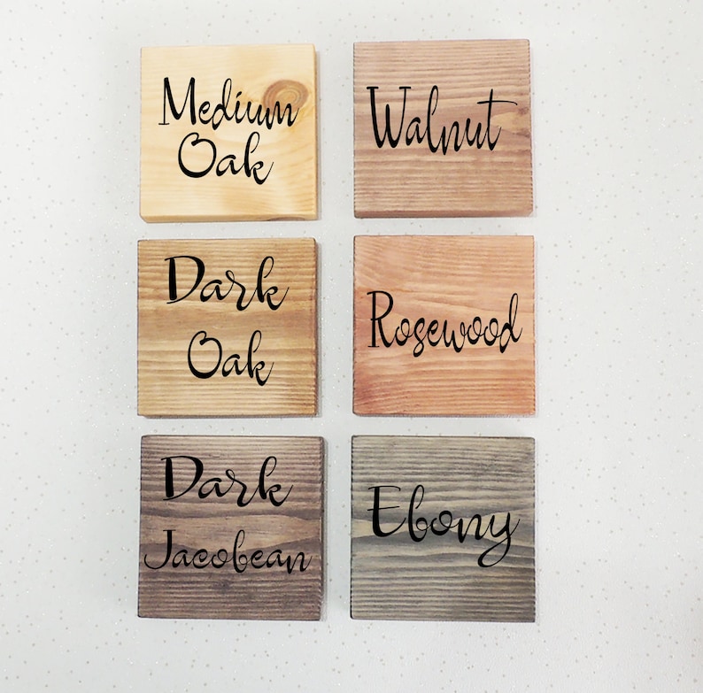 May include: Six wooden squares with different wood stains. The squares are labeled "Medium Oak", "Walnut", "Dark Oak", "Rosewood", "Dark Jacobean", and "Ebony".