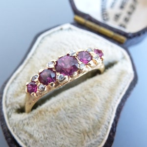 Peut inclure: Une bague en or avec une rangée de cinq pierres précieuses roses et de petites pierres précieuses claires serties dans la bande.