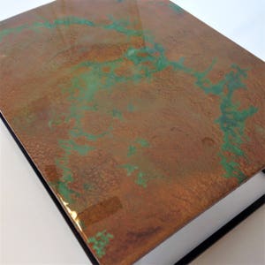 May include: A close-up of a copper box with a green patina. The box has a textured surface and a glossy finish.