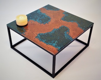 May include: A square coffee table with a black metal frame and a copper top with a green patina finish.