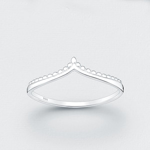 May include: A silver chevron ring featuring a delicate beaded texture along the top edge. The band is polished and smooth, with the hallmark 925 clearly visible on the inner surface, indicating sterling silver composition for this jewelry piece.