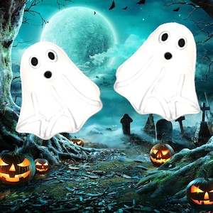 May include: Two white ghost-shaped stud earrings featuring black circular eyes and a small black circular mouth. The ghosts have a smooth, rounded top and a draped, wavy bottom edge, creating a classic spectral appearance for these accessories.