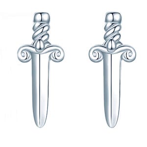 May include: A pair of silver-toned earrings shaped like miniature daggers. Each earring features a smooth, pointed blade, a crossguard with curled ends, and a twisted, rope-like handle design. The metal has a polished, reflective finish.