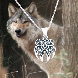 May include: A silver necklace with a wolf paw pendant featuring a Celtic knot design. The pendant is detailed with intricate knots and claws. The necklace is worn by a wolf.