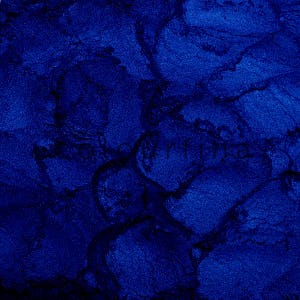 May include: Close-up of a deep blue, textured surface with a marbled pattern. The surface has a slightly metallic sheen.
