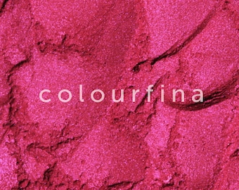 May include: Close-up of a vibrant pink mica powder with a shimmery finish. The powder is finely ground and has a smooth texture.