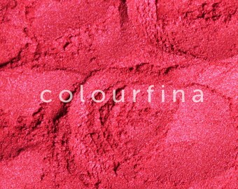 May include: Close-up of a bright red glitter powder. The powder is fine and shimmery, with a slightly metallic sheen.