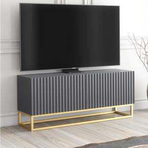 May include: A dark grey TV cabinet with a ribbed front and a gold-coloured metal base. The rectangular cabinet supports a large, black flat-screen television. The design is modern and minimalist, suitable for a contemporary living space.