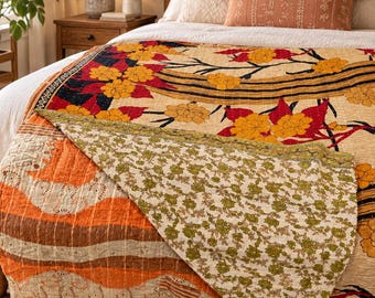 May include: A reversible cotton quilt featuring a cream-colored base with large yellow floral patterns and black branch details on one side, and a contrasting side with orange wavy bands and a small green floral print on a cream background.