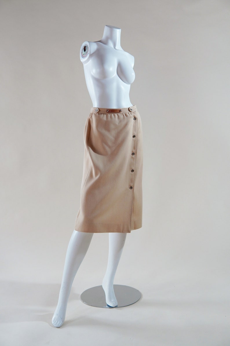 1970s Courrèges wrap skirt tan beige vintage designer knee length skirt with silver buttons and leather nameplate logo at waist image 2