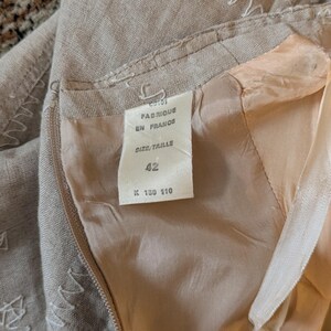 May include: A beige linen skirt with a white label that says "Fabrique en France" and "Size/Taille 42 K 130 110".