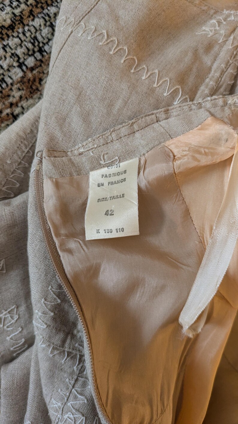 May include: A beige linen skirt with a white label that says "Fabrique en France" and "Size/Taille 42 K 130 110".