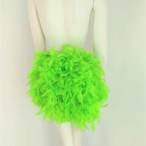 May include: A bright neon green feather skirt. The skirt is made of many layers of feathers and is very full.