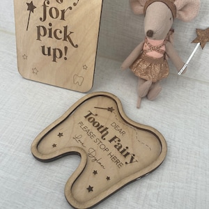 Peut inclure: Boîte à dents de fée en bois en forme de dent avec le texte "Chère fée des dents S'il vous plaît, arrêtez-vous ici Amour Dylan" et un motif d'étoile.