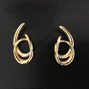 May include: A pair of gold-toned earrings with a simple, modern design. Each earring features two interlocking loops.
