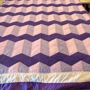 May include: A white ceramic mug with a black handle and the text "But First, Coffee" in a black, bold font. The mug is sitting on a wooden surface. The mug is approximately 4 inches tall.