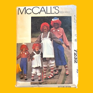 May include: McCall's sewing pattern number 7232 for a Raggedy Ann costume. The pattern includes instructions for making a dress, pants, and a hat. The pattern is illustrated with three children wearing the costumes.