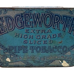 May include: Vintage Edgeworth pipe tobacco tin. The rectangular tin features a blue background with the words "EDGEWORTH EXTRA HIGH GRADE SLICED PIPE TOBACCO" in white and blue lettering. The tin also includes the text "RUS & BRO. CO. RICHMOND, VA. U.S.A."