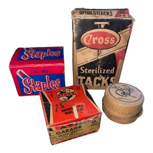 May include: Three boxes of vintage office supplies. A red box with "Staples" printed on it, a red and white box with "Atlas" printed on it, and a brown box with "Cross Sterilized Tacks" printed on it.