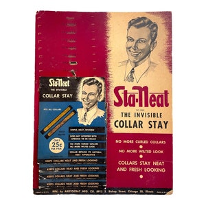 May include: A vintage cardboard display card for Sta-Neat collar stays. The card features a man wearing a shirt and tie, and the text "Sta-Neat The Invisible Collar Stay" in red and white. The card also includes the text "No more curled collars, No more wilted look, Collars stay neat and fresh looking." and "Only 25c per pair".