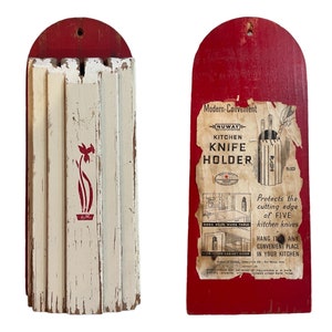 May include: A red wooden knife holder with a white painted front panel featuring a floral design. The holder has a sign attached to it that reads "Modern-Convenient Nuway Kitchen Knife Holder No. 475" and describes the product's features.
