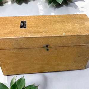 May include: A wooden box with a metal latch and a label that reads "F.T.O. Leipzig".