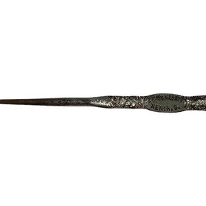 May include: A silver shoe horn with an ornate design and the inscription "Keys & Esser, Kenosha, Wis."