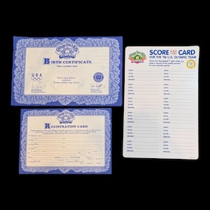 May include: Three vintage Cabbage Patch Kids collectible items. Includes a blue Birth Certificate, a Registration Card, and a Score Card for the 1996 U.S. Olympic Team. The items have a blue floral border and text.