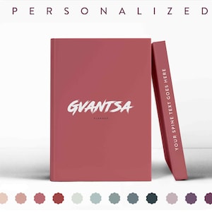 May include: A red personalized planner with the name "GVANTSA" printed in white on the front cover. The spine of the planner is also red and has the text "YOUR SPINE TEXT GOES HERE" printed in white.