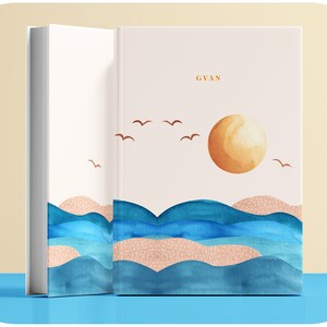 Peut inclure: Un livre blanc avec une illustration aquarelle d'un océan bleu avec des vagues, un soleil jaune et des oiseaux bruns. Le livre porte le mot "GYAN" imprimé sur la couverture.