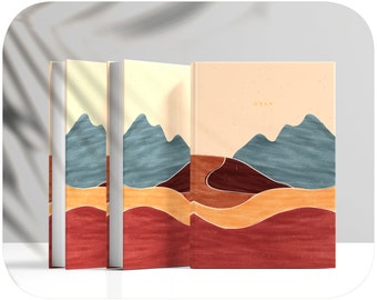 Puede incluir: Tres libros de tapa dura con un diseño de paisaje que presenta montañas azules, colinas naranjas y rojas, y la palabra "OVAN" en la portada.