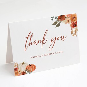 May include: Thank you card with a watercolor design of fall leaves, pumpkins, and flowers. The text reads "thank you" with the names Andrea & Patrick Lewis below.