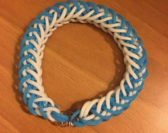 May include: A blue and white rubber band bracelet with a silver clasp.