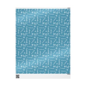 May include: A light blue blanket featuring a repeating pattern of the name "Makayla" and the letter "M" interspersed with snowflakes. The design is in white, creating a contrasting effect against the blue background.