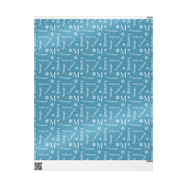 May include: A light blue blanket featuring a repeating pattern of the name "Makayla" and the letter "M" interspersed with snowflakes. The design is in white, creating a contrasting effect against the blue background.