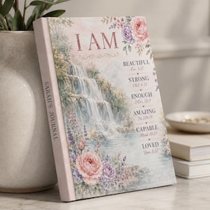 May include: A hardcover journal titled Sarah's Journal featuring a waterfall illustration, floral accents, and the text I AM followed by the words BEAUTIFUL, STRONG, ENOUGH, AMAZING, CAPABLE, and LOVED, each paired with a corresponding Bible verse reference.