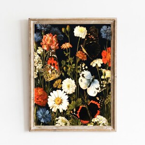 Può includere: Una stampa artistica da parete rettangolare incorniciata con uno sfondo nero scuro pieno di vari fiori colorati, tra cui margherite bianche, calendule arancioni e fiordalisi blu, intervallati da diverse farfalle nei toni dell'arancione, nero e bianco.