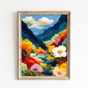 May include: A framed oil painting featuring a thick impasto texture depicting a vibrant mountain landscape. The scene includes deep blue peaks, a bright blue sky with white clouds, and a foreground filled with colorful red, yellow, and white flowers.