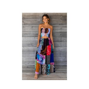 May include: A two-piece set consisting of a strapless tube top and a floor-length maxi skirt. Both pieces feature a patchwork design with various colorful patterns, including animal prints, tie-dye, floral motifs, and geometric shapes in multiple colors.