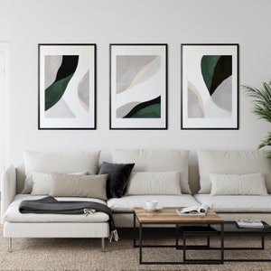 Puede incluir: Tres impresiones de arte abstracto enmarcadas con marcos negros y montajes blancos. Las impresiones presentan formas abstractas en tonos de verde, negro y blanco.