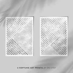 May include: Two black and white geometric abstract art prints with a textured, distressed look. The prints feature a pattern of intersecting diagonal lines.