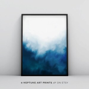 May include: A framed abstract painting with a blue and white watercolor design. The painting is in a black frame and has a white background.