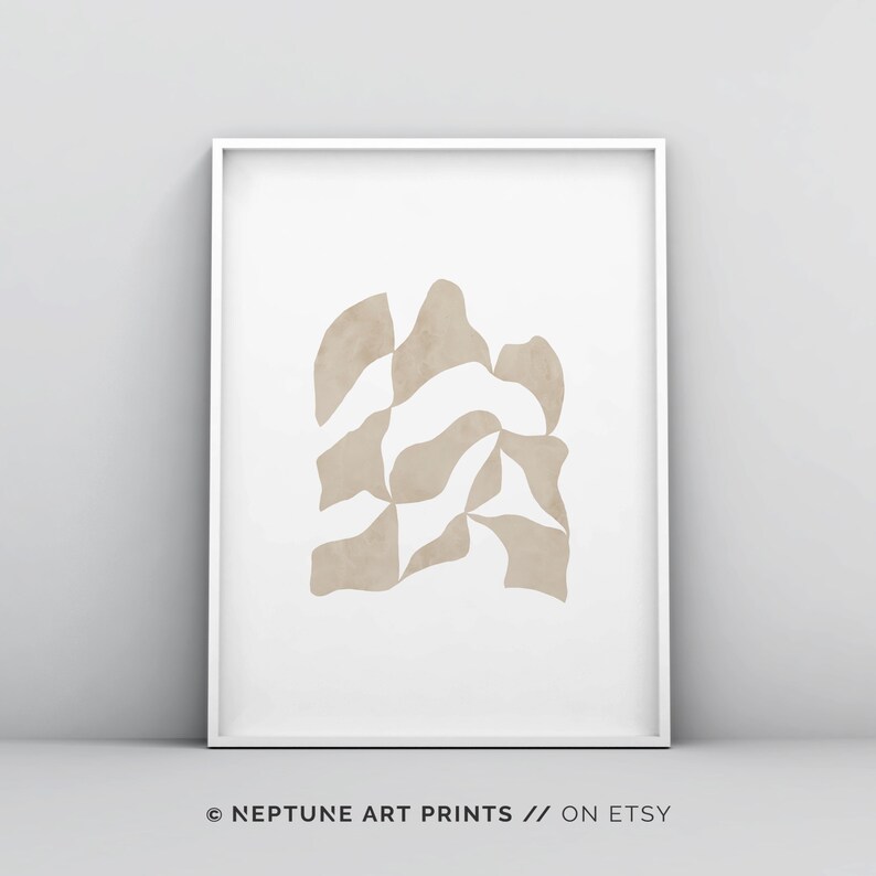 May include: Abstract art print featuring a beige geometric shape on a white background. The print is framed in a white frame. The text "NEPTUNE ART PRINTS // ON ETSY" is at the bottom of the image.