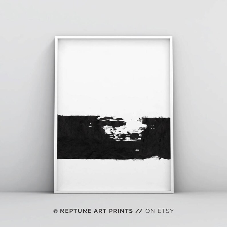May include: Black and white abstract art print with a thick black brushstroke across the bottom half of the print. The print is framed in a white frame.
