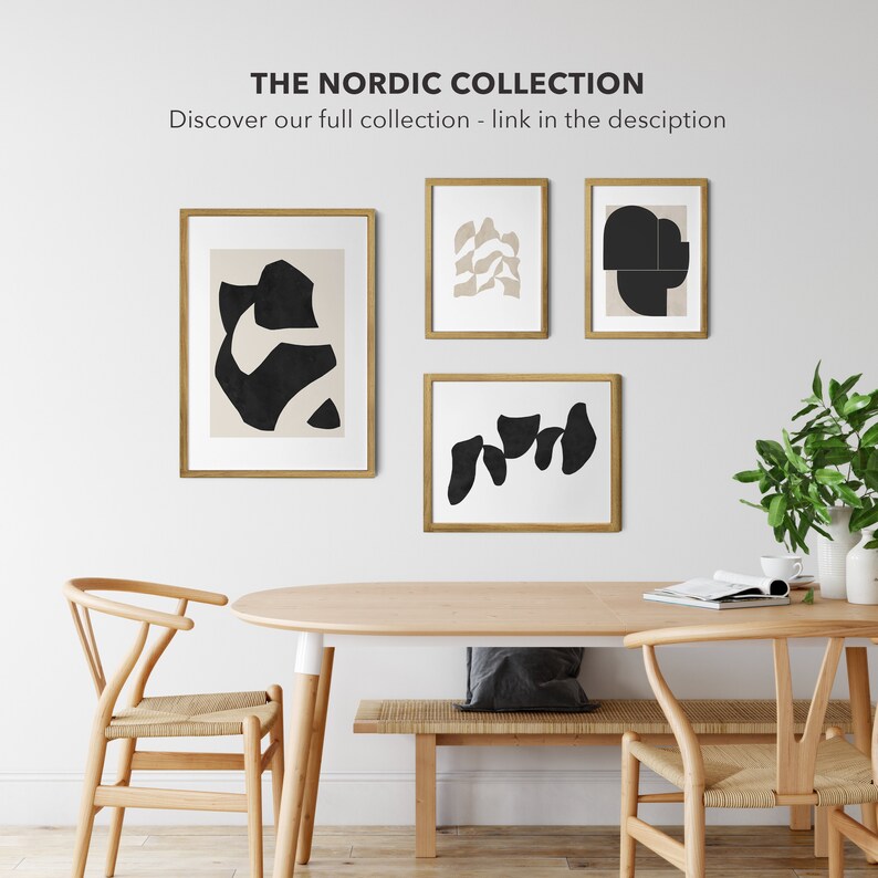 May include: Four framed abstract art prints with black and beige shapes on a white background. The prints are hanging on a white wall above a wooden table with two chairs.