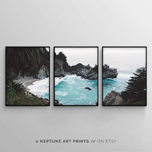 May include: A three-part panoramic photo of a rocky coastline with turquoise water crashing against the shore. The photo is framed in black and is ready to hang on a wall.