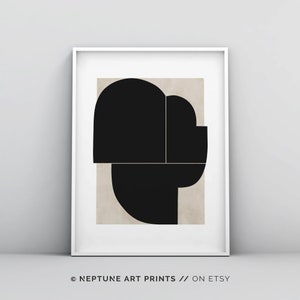 May include: Abstract geometric art print with black shapes on a beige background. The print is framed in a white frame.
