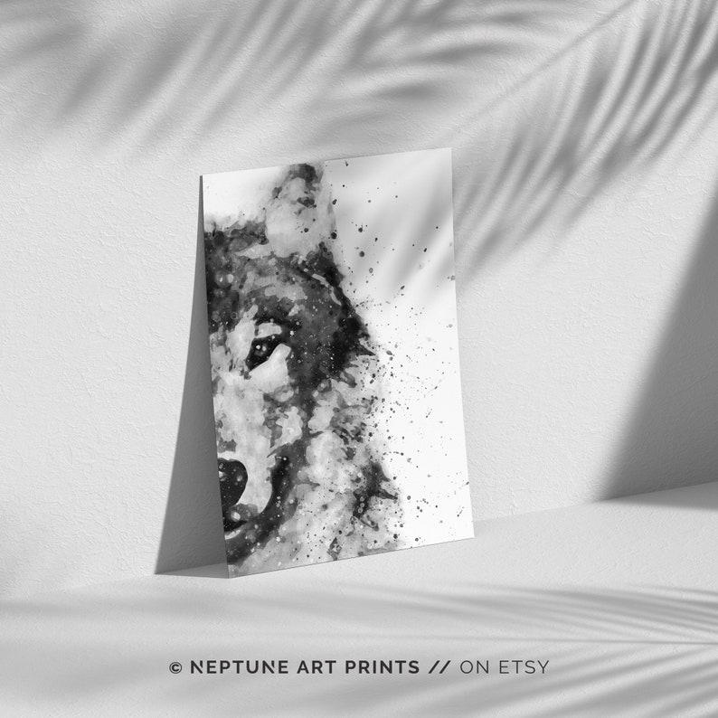 May include: Black and white watercolour painting of a wolf's face. The wolf is looking to the right, and the painting has a splattered effect.