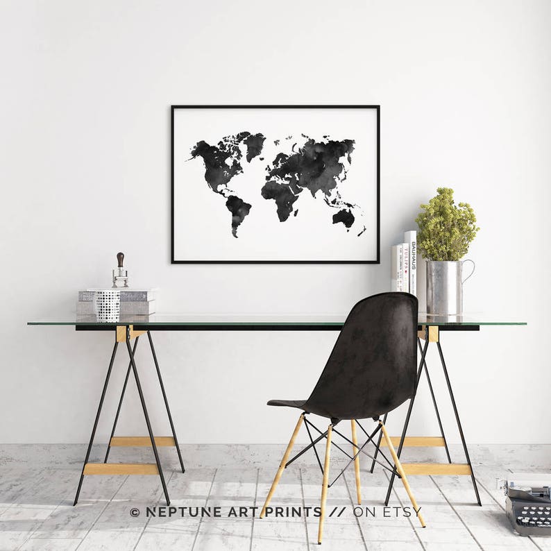 Peut inclure: Impression aquarelle de la carte du monde en noir et blanc dans un cadre noir accroch&eacute; &agrave; un mur blanc au-dessus d'un bureau en verre avec une chaise noire. Le bureau est sur un sol en bois.