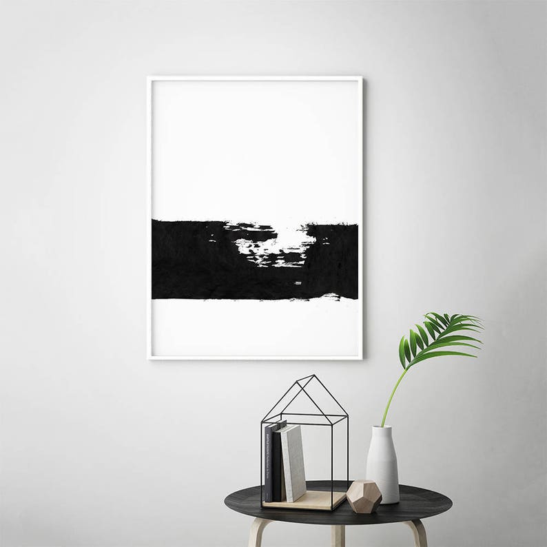 May include: Black and white abstract art print in a white frame. The print features a thick black brushstroke across the bottom half of the image.